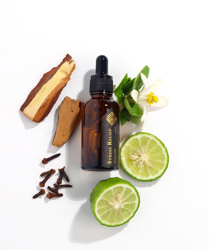 About Flat lay of essential oil bottle with citrus, cloves, and wood for aromatherapy.